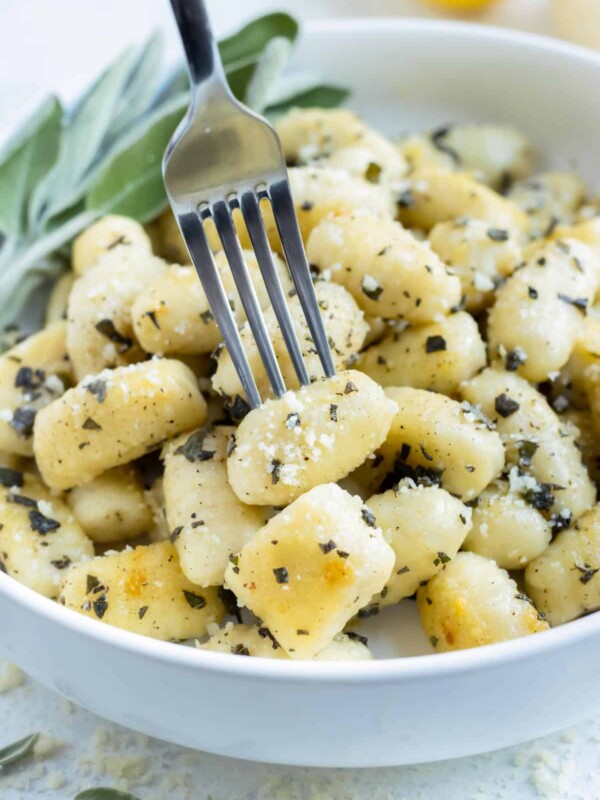 Gluten-free gnocchi is enjoyed with a fork from a bowl.