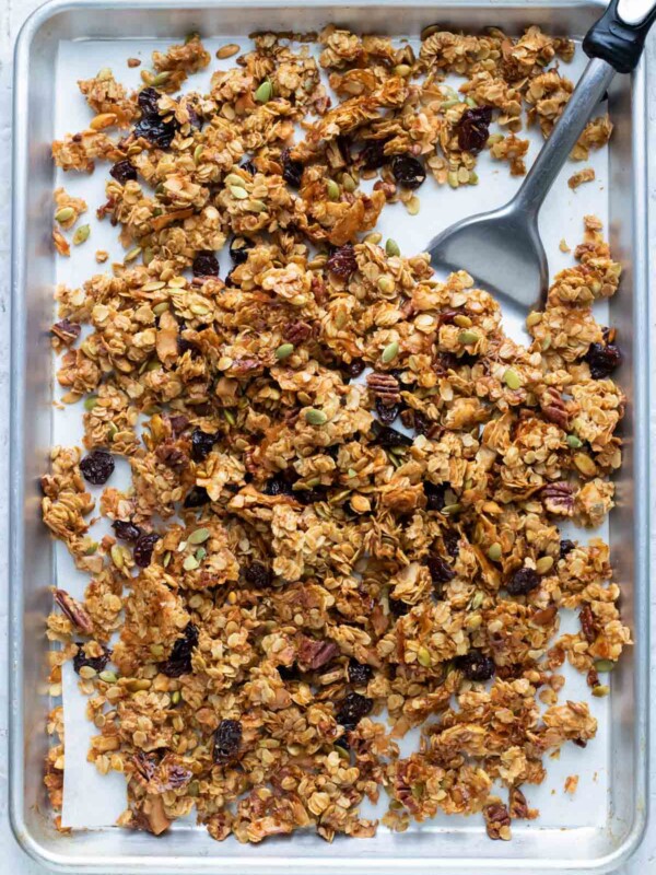 After baking the granola, a spatula breaks the mixture into clusters.