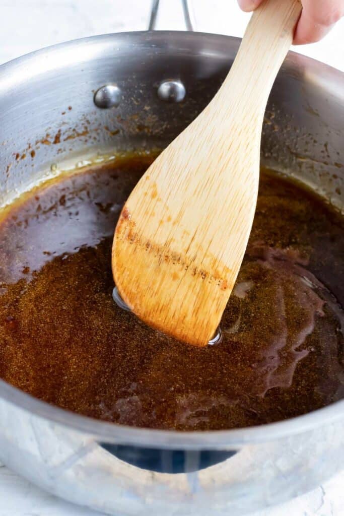 A saucepan full of syrup, sugar, and oil as the coating for a healthy vegan granola recipe.