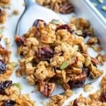 A baking sheet full of an easy and healthy granola recipe with cherries, pecans, and coconut.