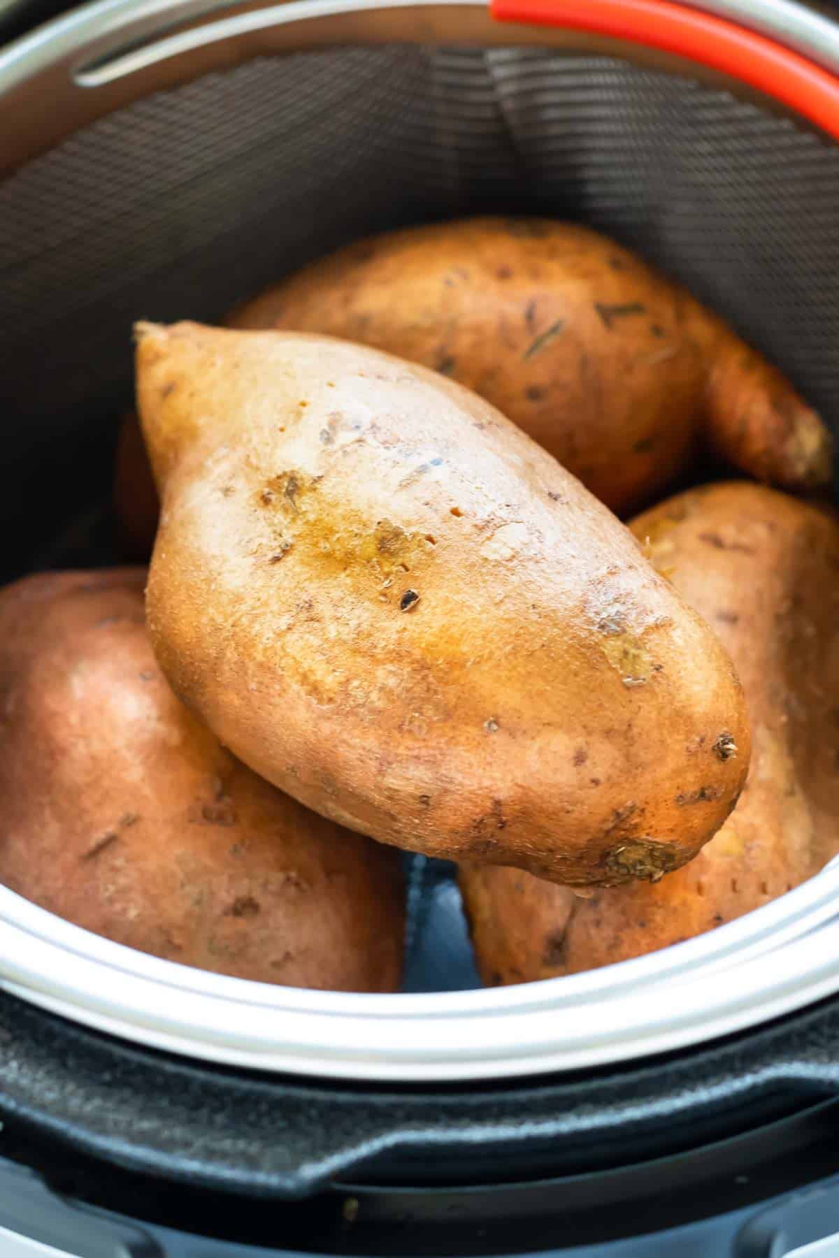 Sweet potatoes piled in an Instant Pot steamer basket for an easy pressure cooker side dish.
