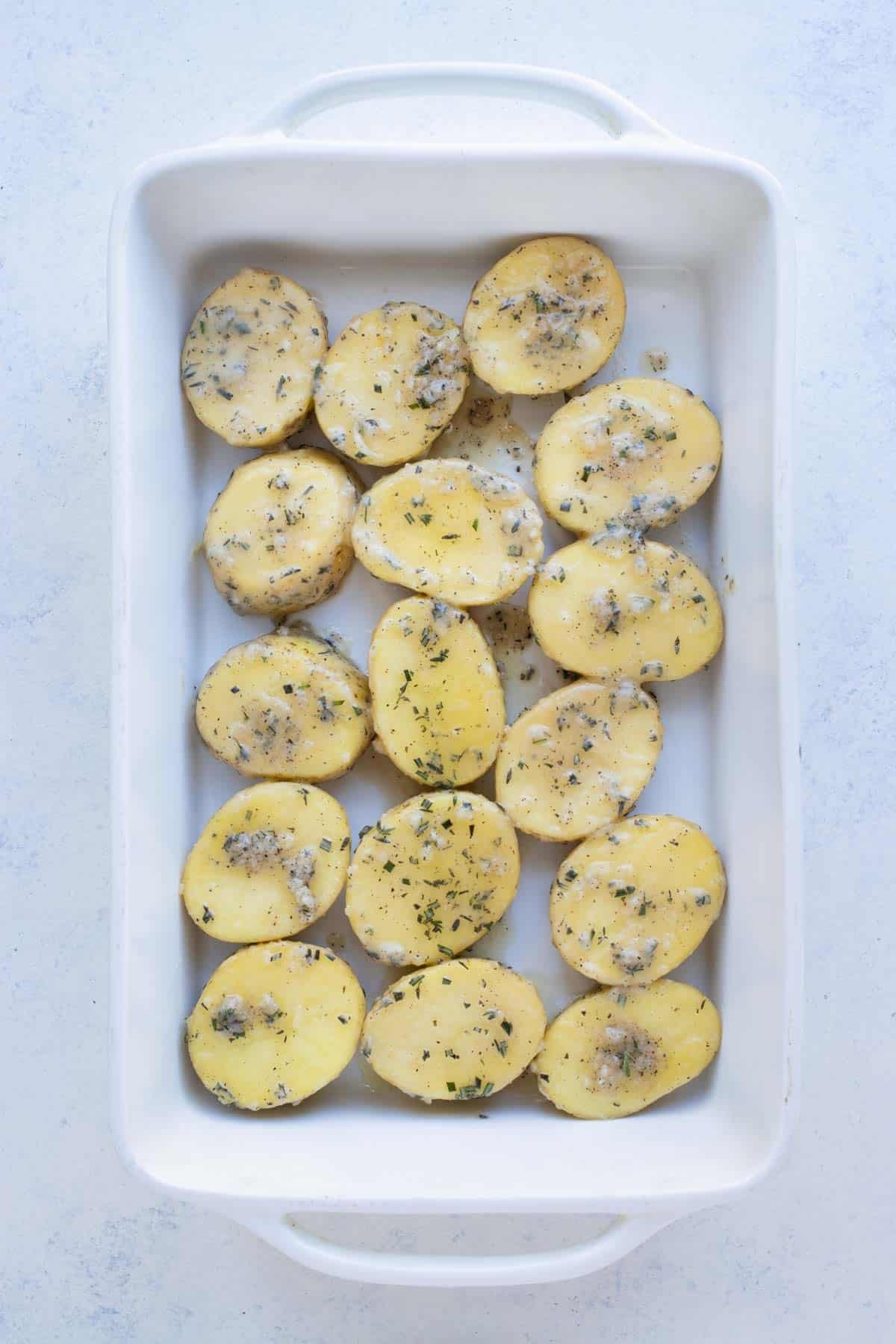 A baking dish with potatoes covered in sauce.