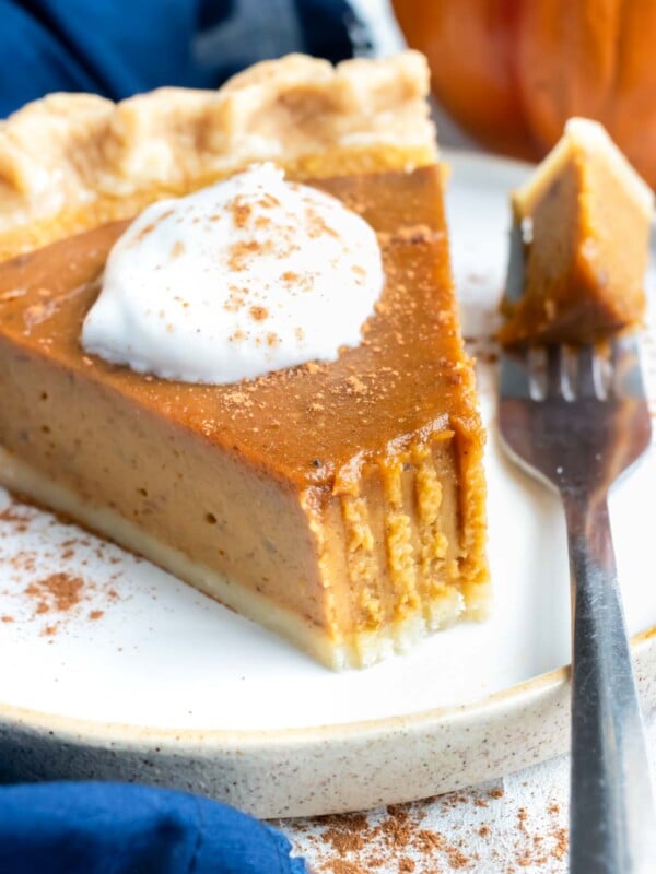 A bite has been taken out of a slice of pumpkin pie.