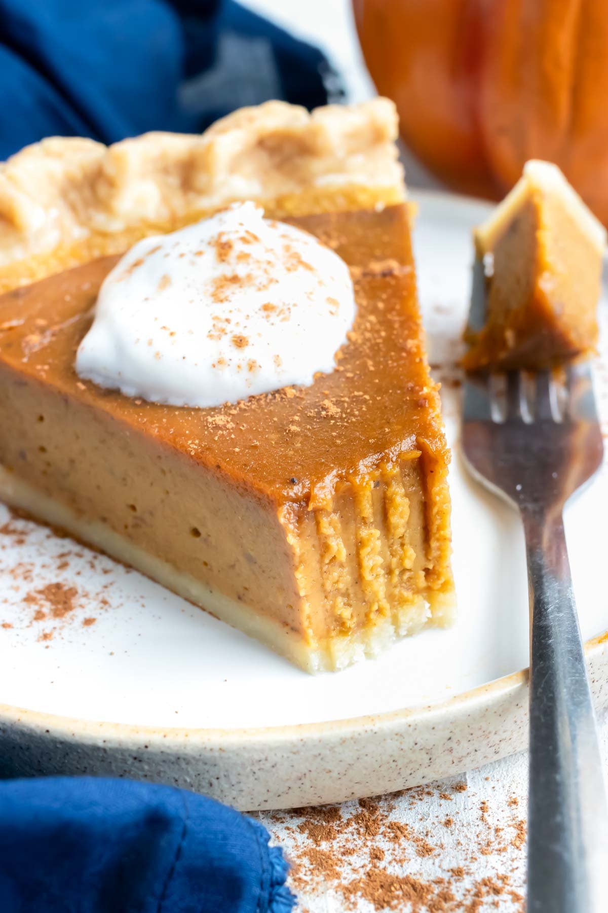A bite has been taken out of a slice of pumpkin pie.
