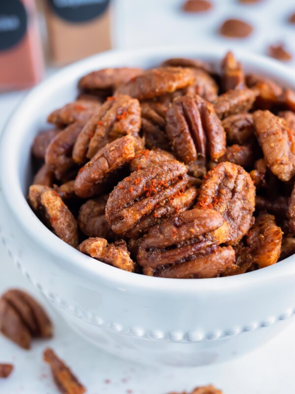 Oven toasted pecans are put in a bowl on the counter for a keto snack.