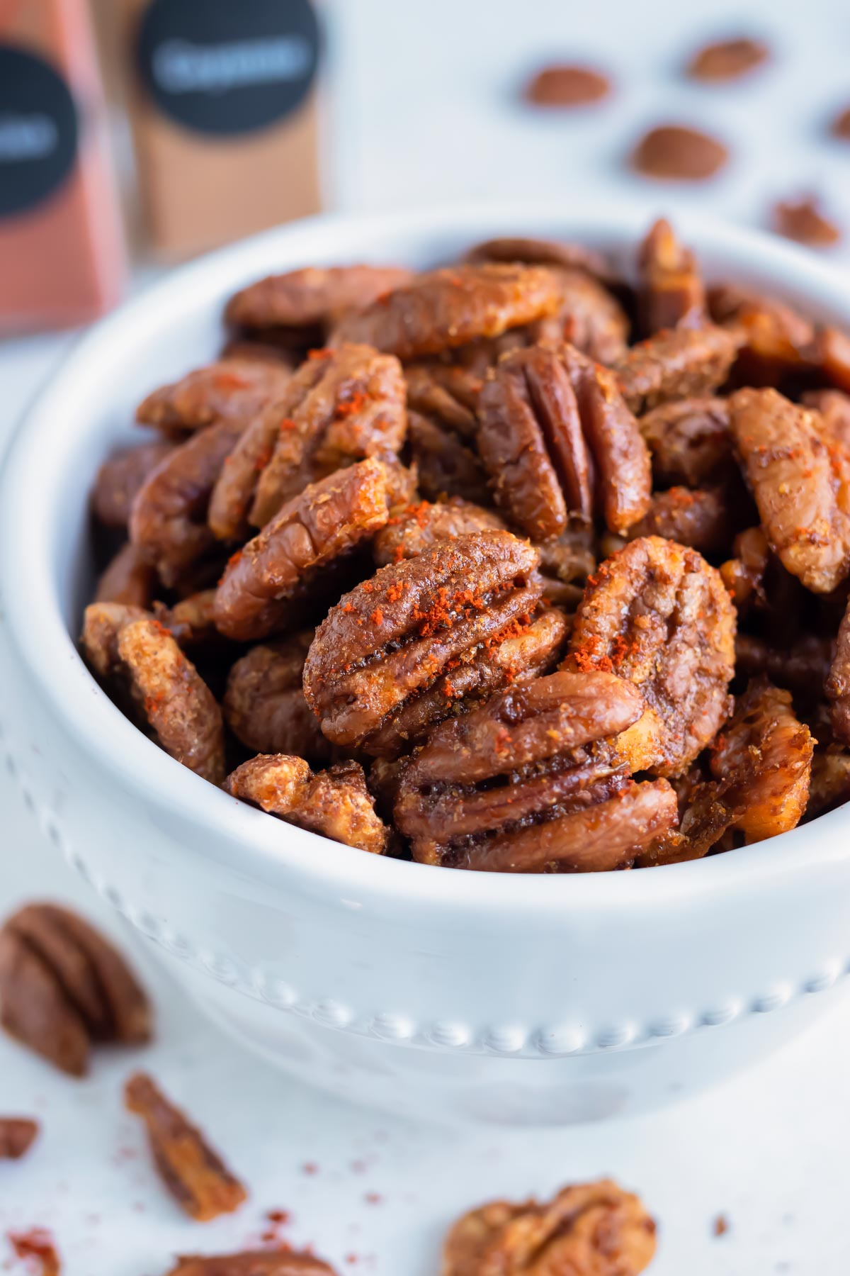 Oven toasted pecans are put in a bowl on the counter for a keto snack.