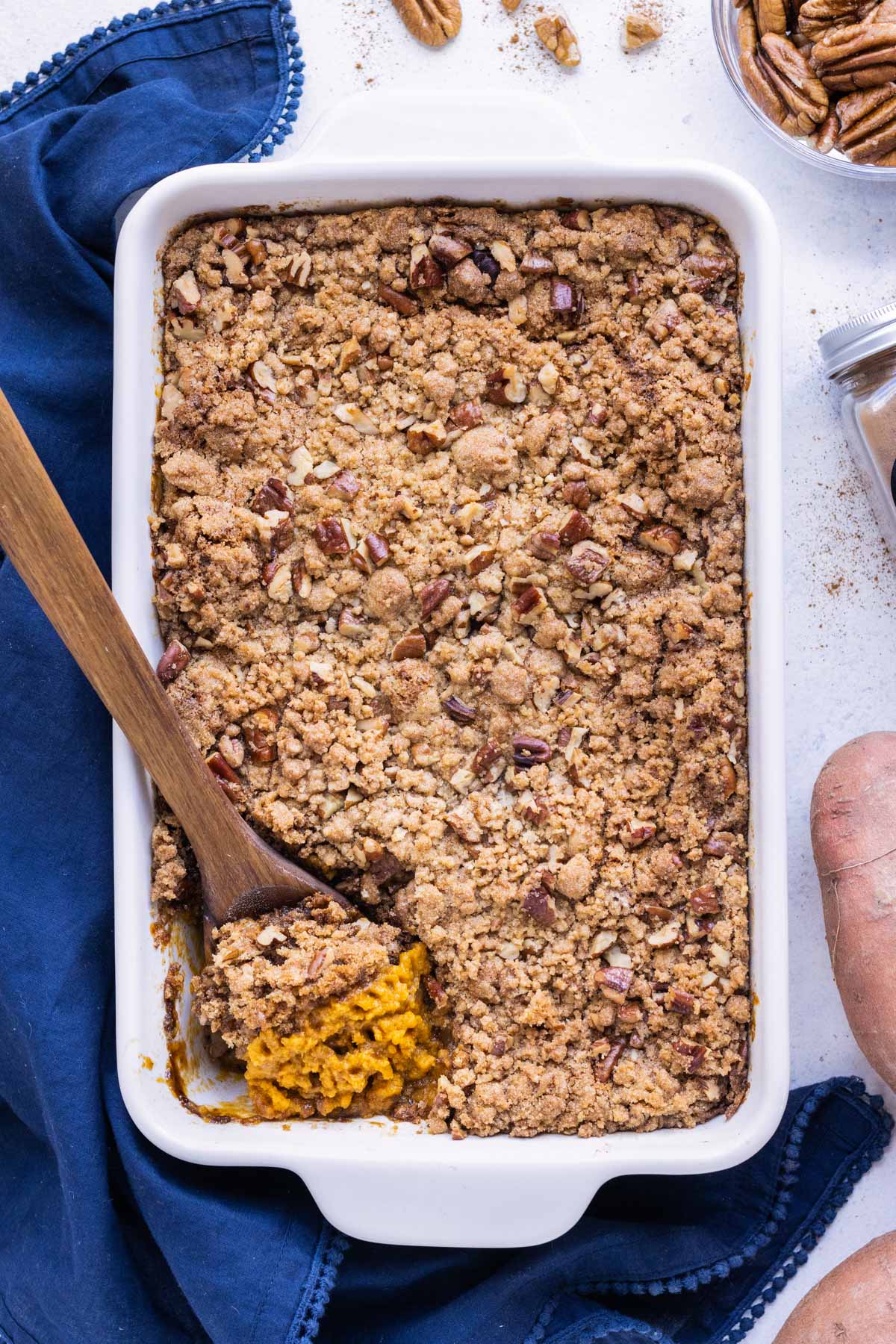 A baked sweet potato casserole with a crunchy pecan crumble made with brown sugar is served for Thanksgiving.