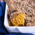 A baked sweet potato casserole with a crunchy pecan crumble made with brown sugar is served for Thanksgiving.