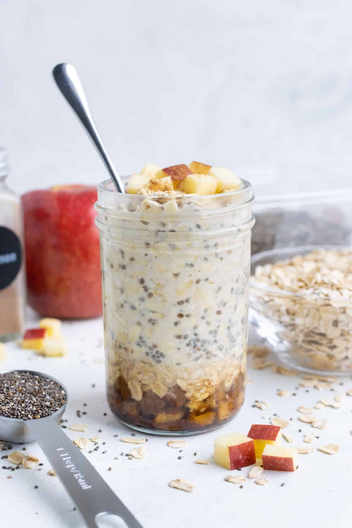 A serving of Apple Cinnamon Overnight Oats on a wood table.