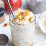 A mason jar filled with gluten-free apple cinnamon overnight oats for a healthy breakfast.