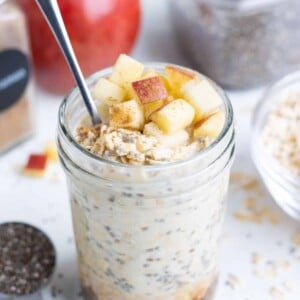 A mason jar filled with gluten-free apple cinnamon overnight oats for a healthy breakfast.