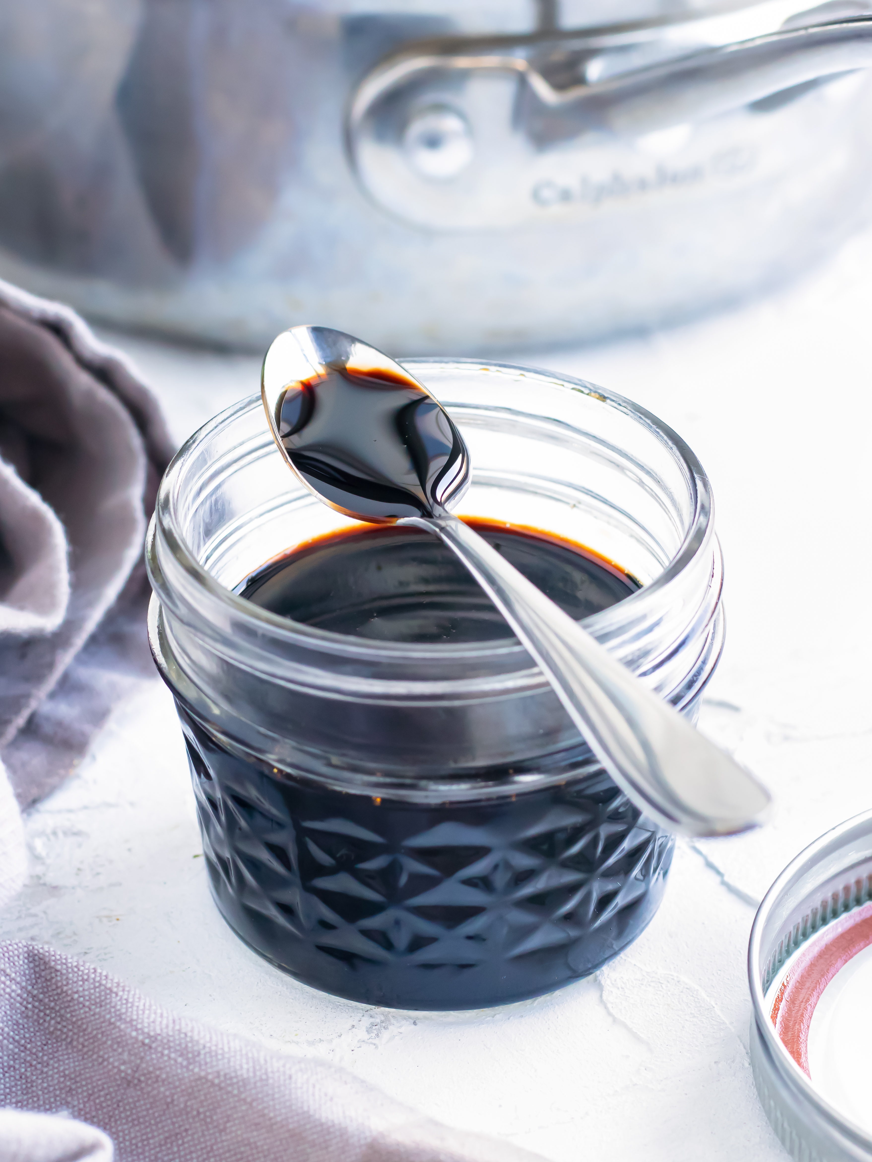 Balsamic reduction recipe in a clear mason jar with a spoon.