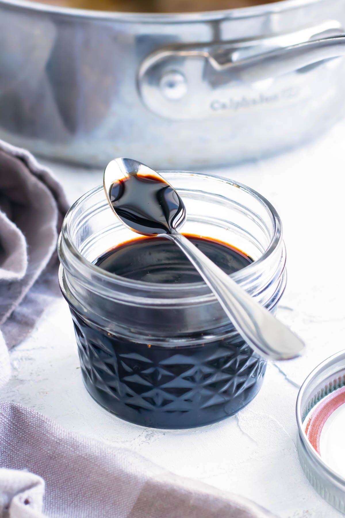 Balsamic reduction recipe in a clear mason jar with a spoon.