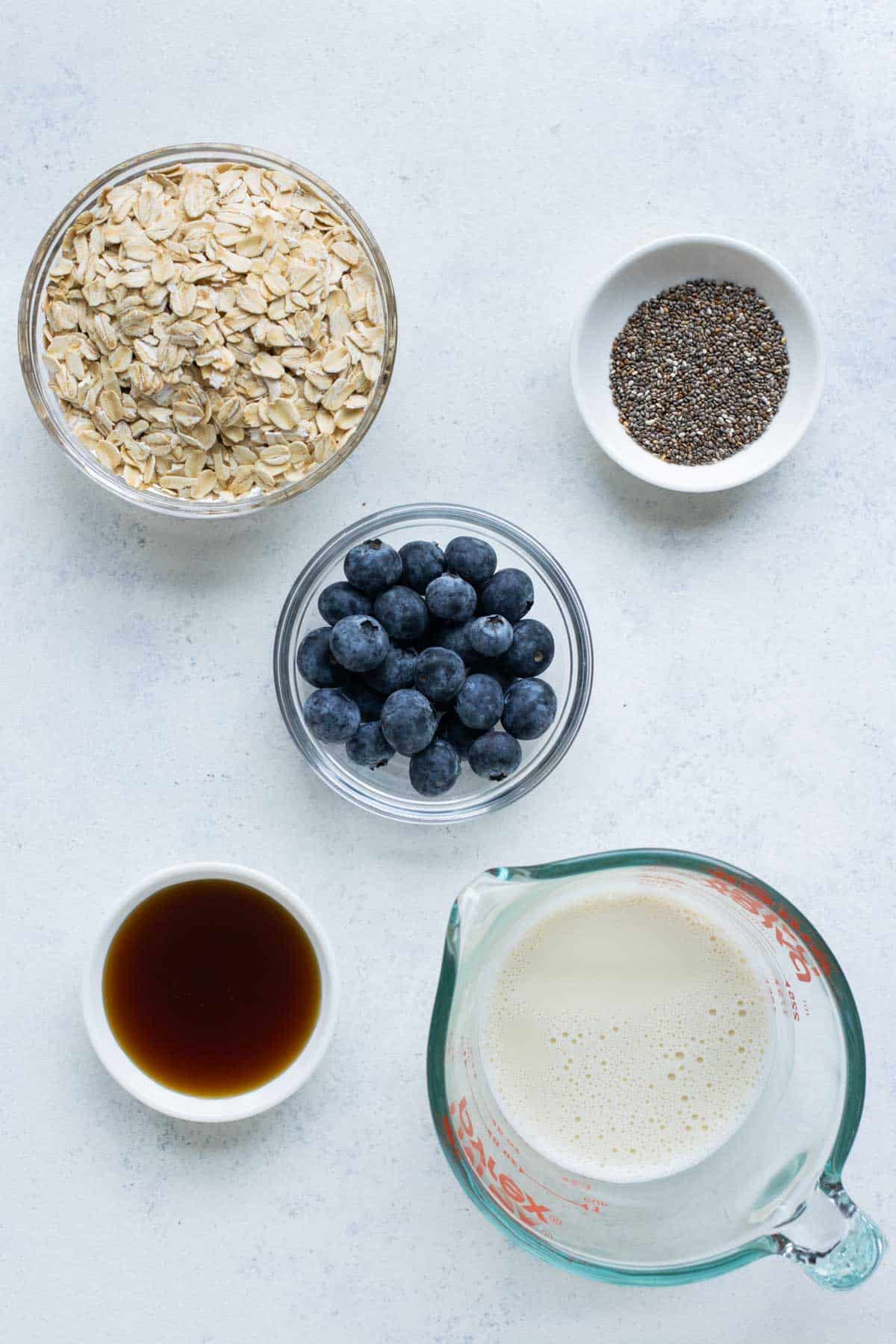 Rolled oats, blueberries, chia seeds, milk, and maple syrup are the ingredients for this recipe.