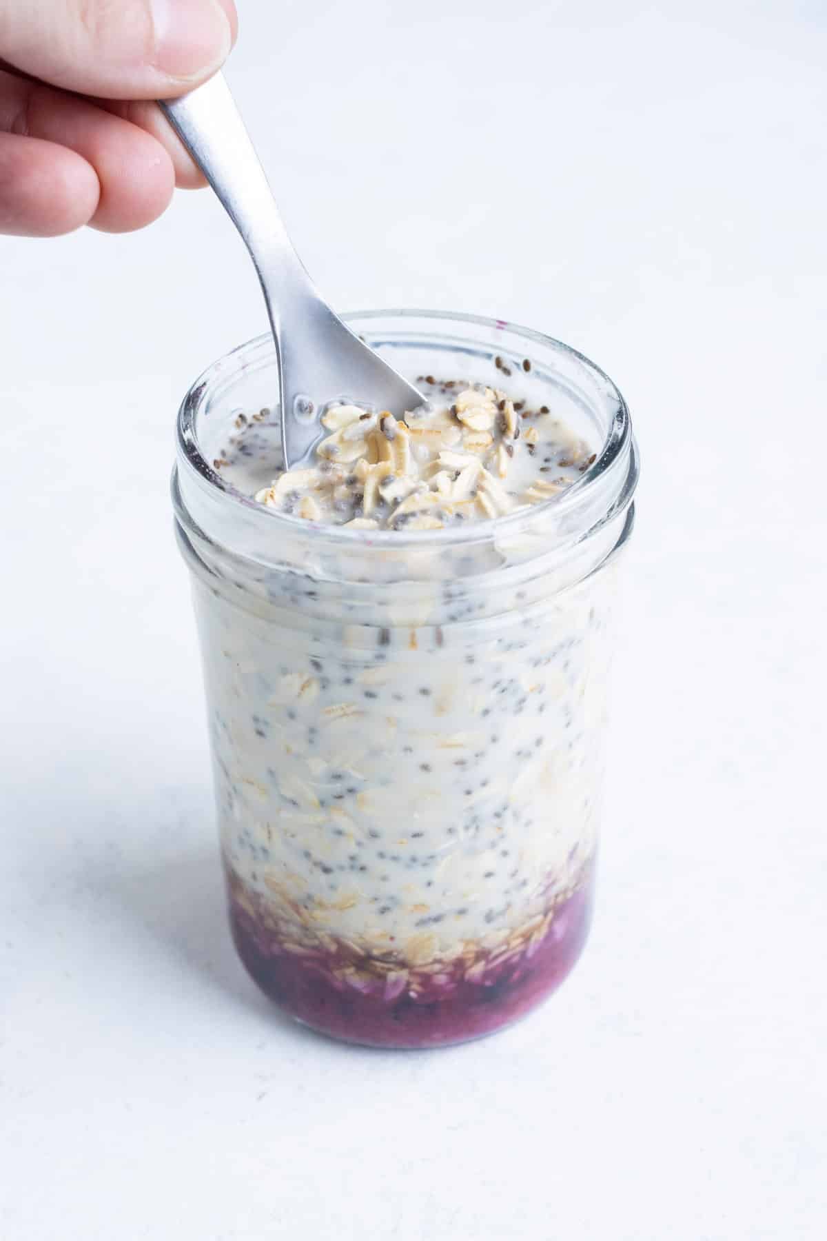 A spoon stirs the oatmeal ingredients.