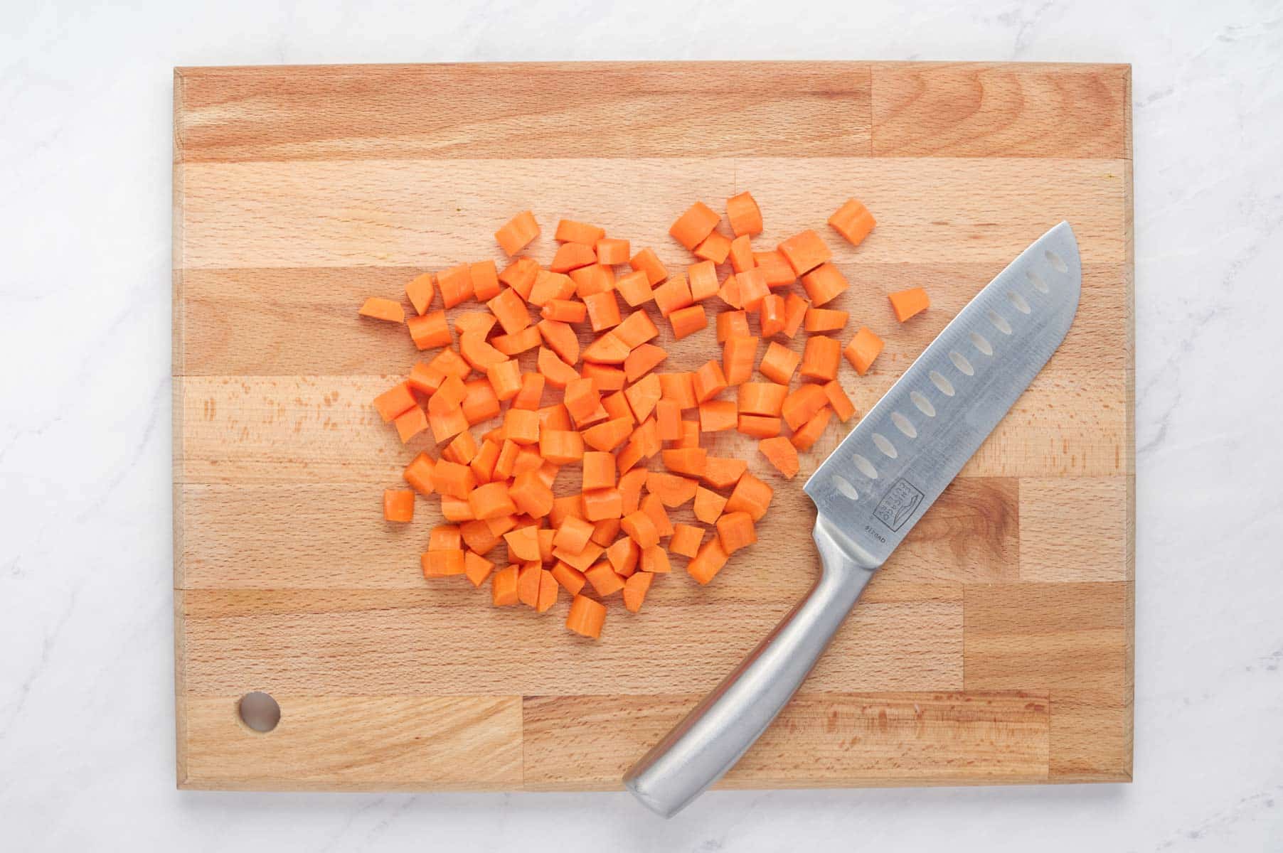 Carrots are chopped on a cutting board.