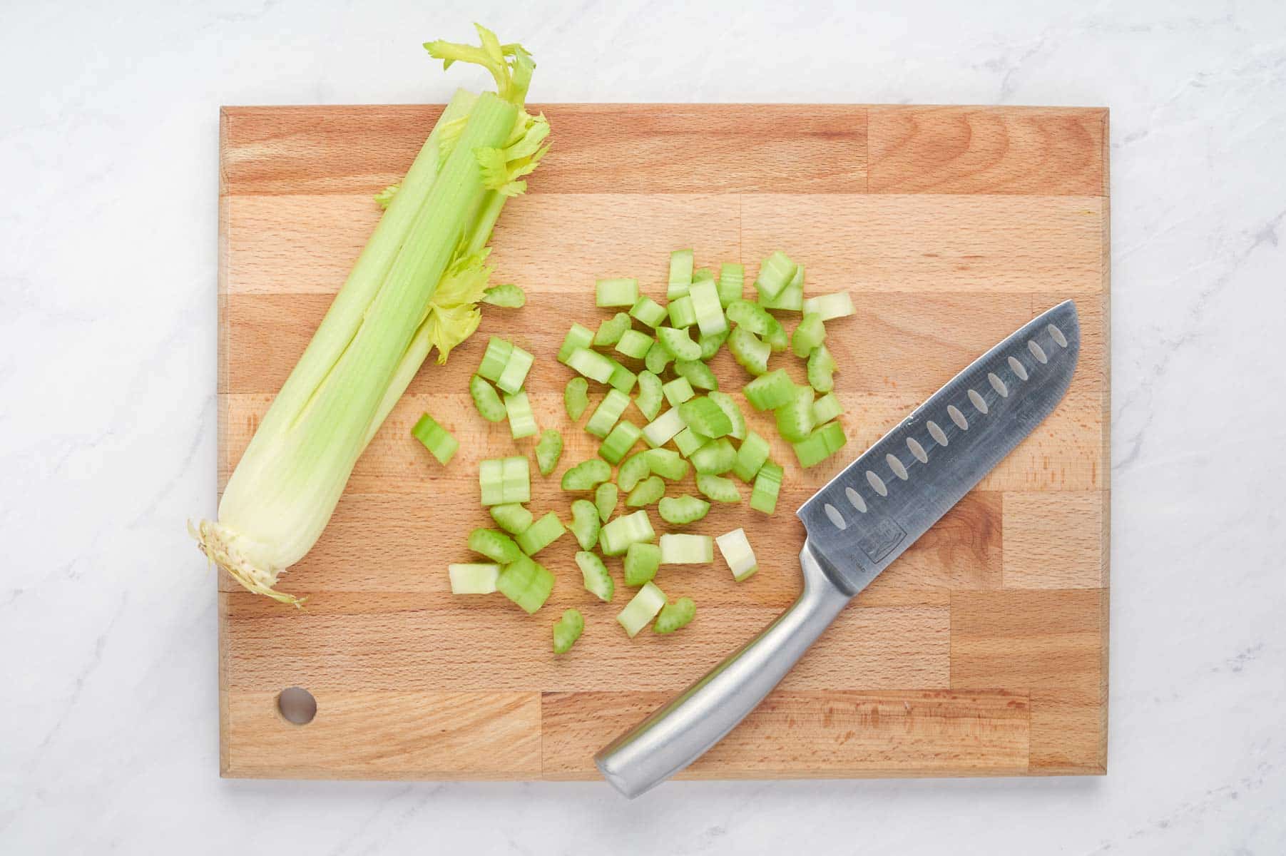 Celery is chopped on a cutting board.