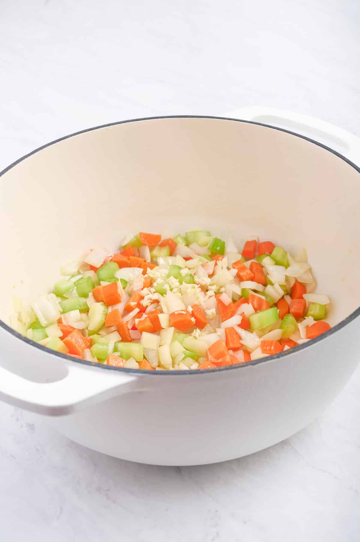 Saute mirepoix of onions, celery, and carrots as the base for the soup in a Dutch oven or pot.