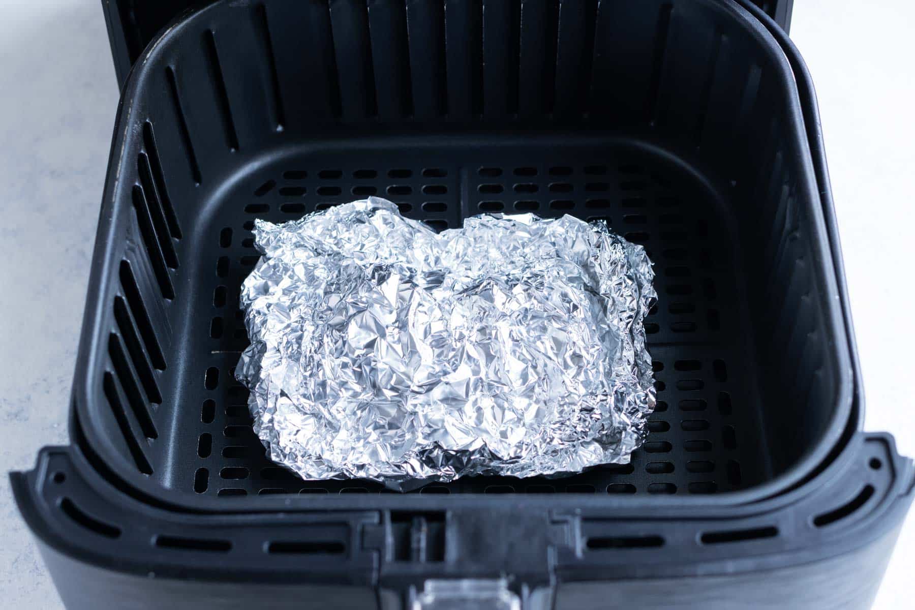 Crinkled tin foil molded into a square with the edges folded up.