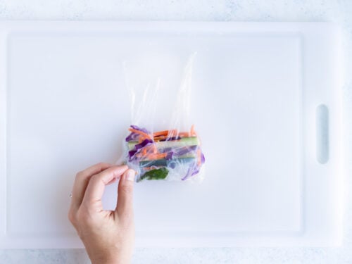Showing how to carefully roll a spring roll.