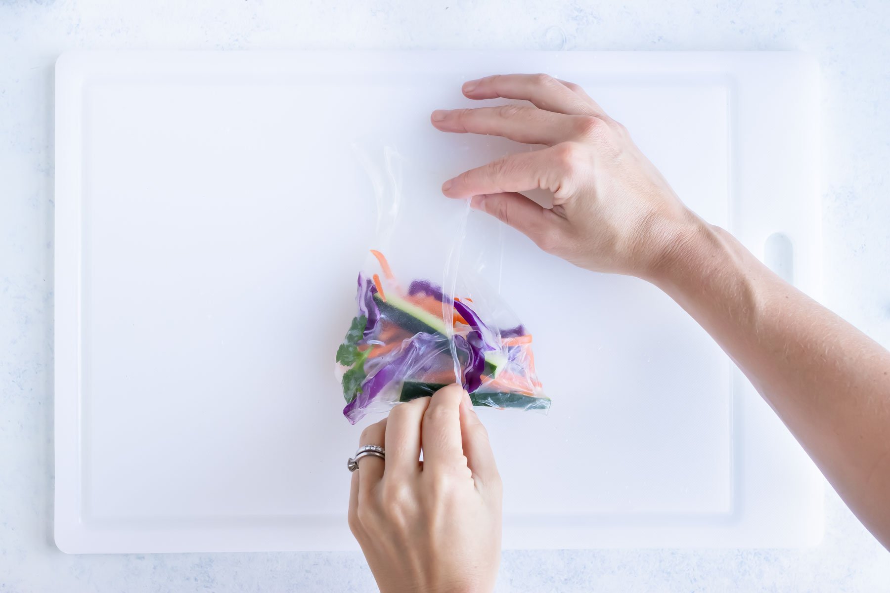 Showing how to carefully roll a spring roll.