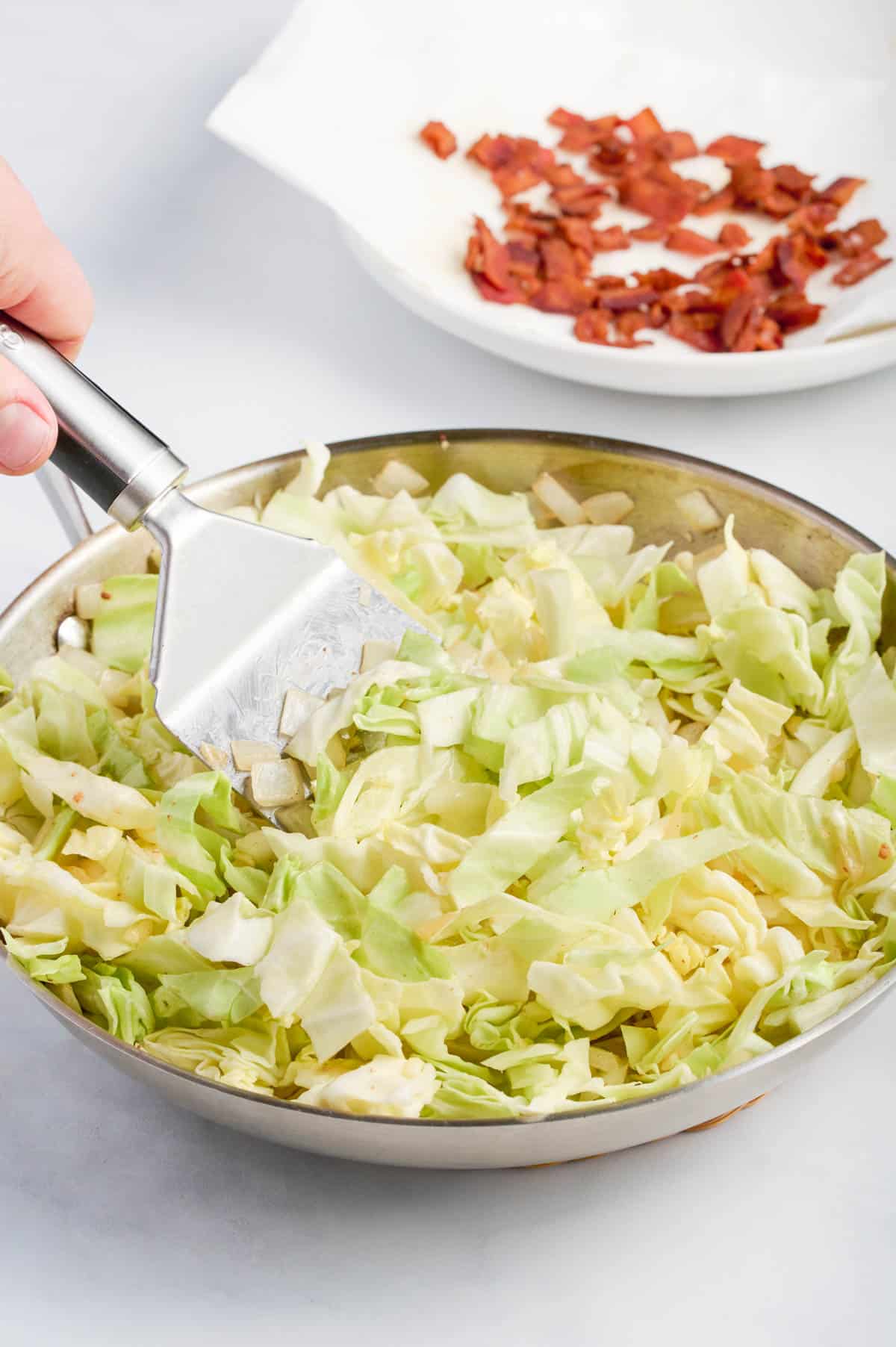 A spatula stirs the cabbage.