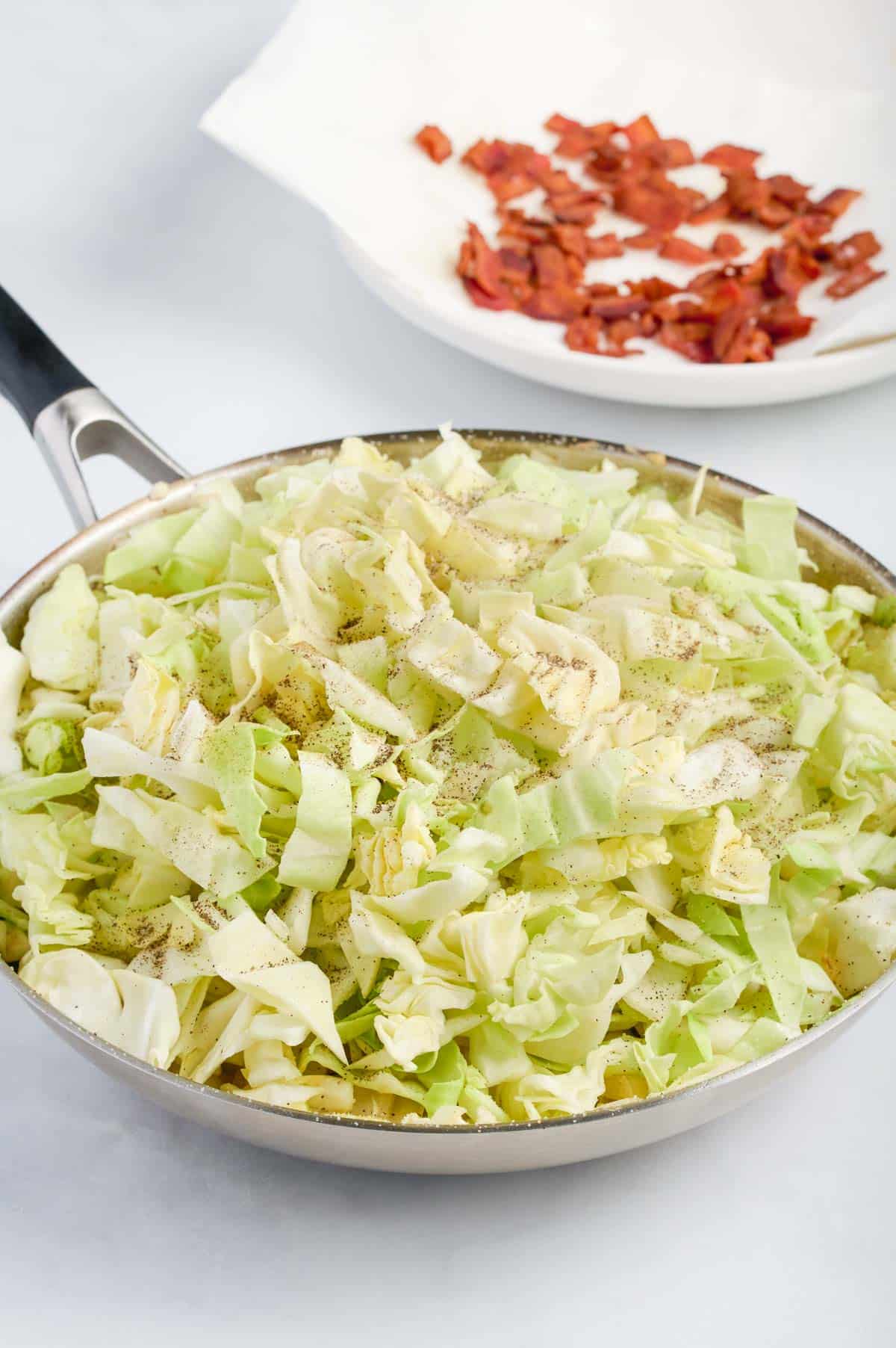 The second half of the cabbage is added to the skillet.