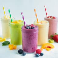 5 different types of fruit smoothies are set on the counter.