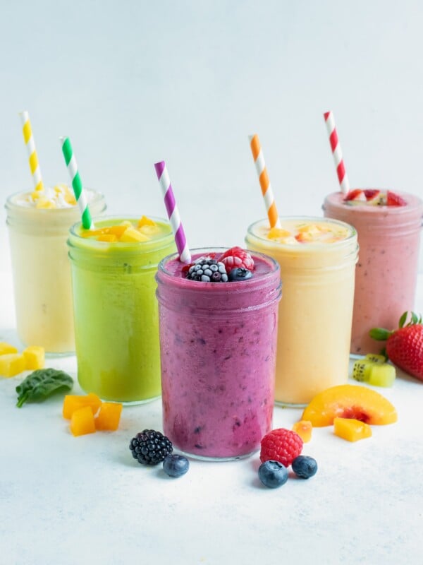 5 different types of fruit smoothies are set on the counter.