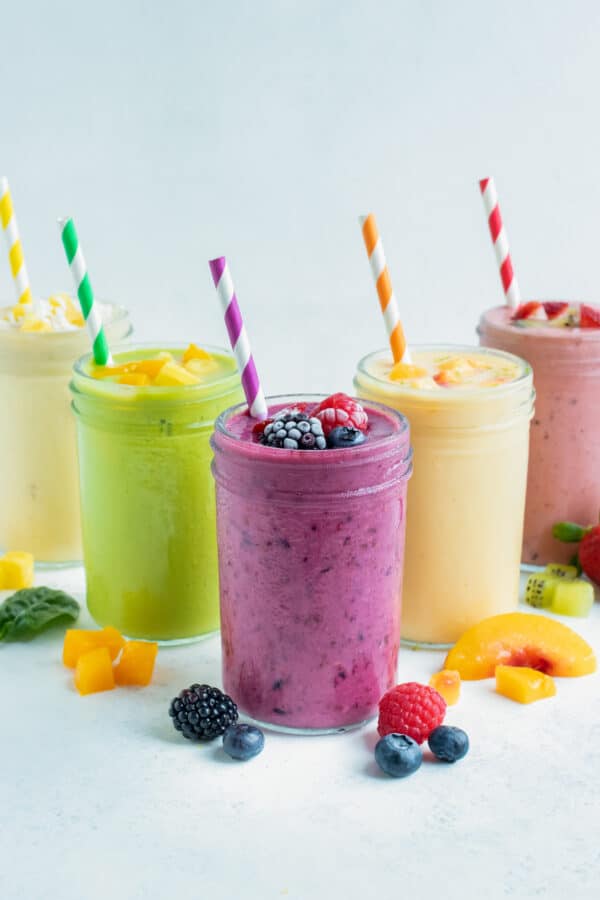 5 different types of fruit smoothies are set on the counter.