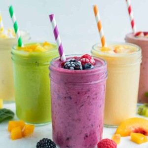 Many different flavors of frozen fruit smoothie recipes are set on the counter.