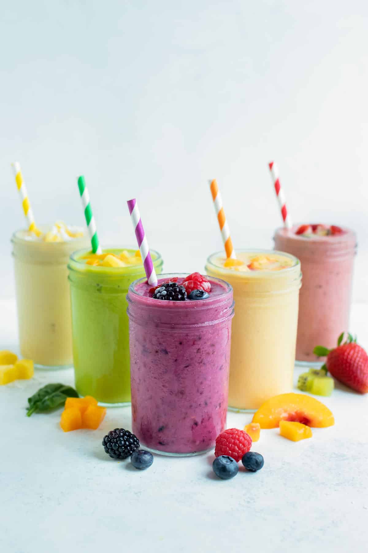 Many different flavors of frozen fruit smoothie recipes are set on the counter.