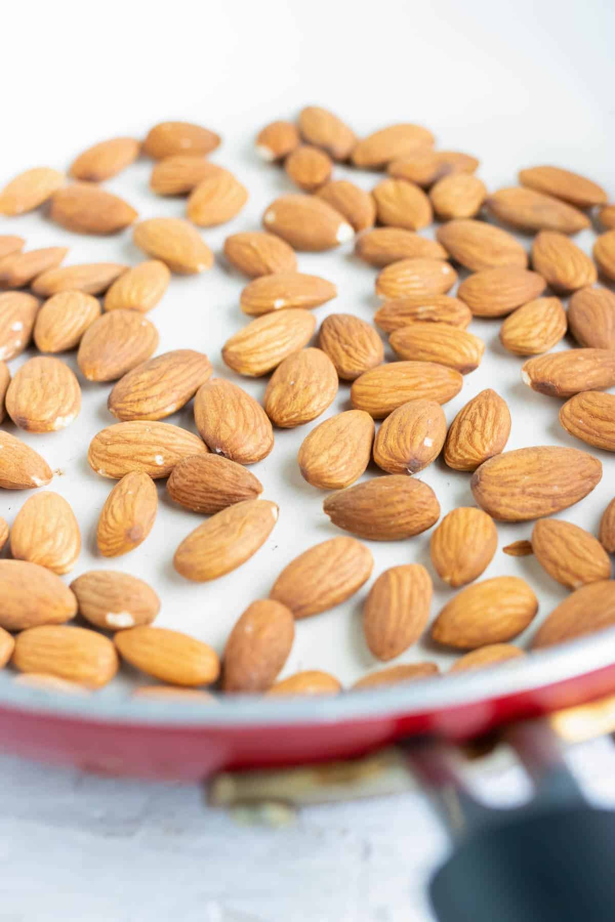 Almonds placed on a parchment paper lined baking sheet.