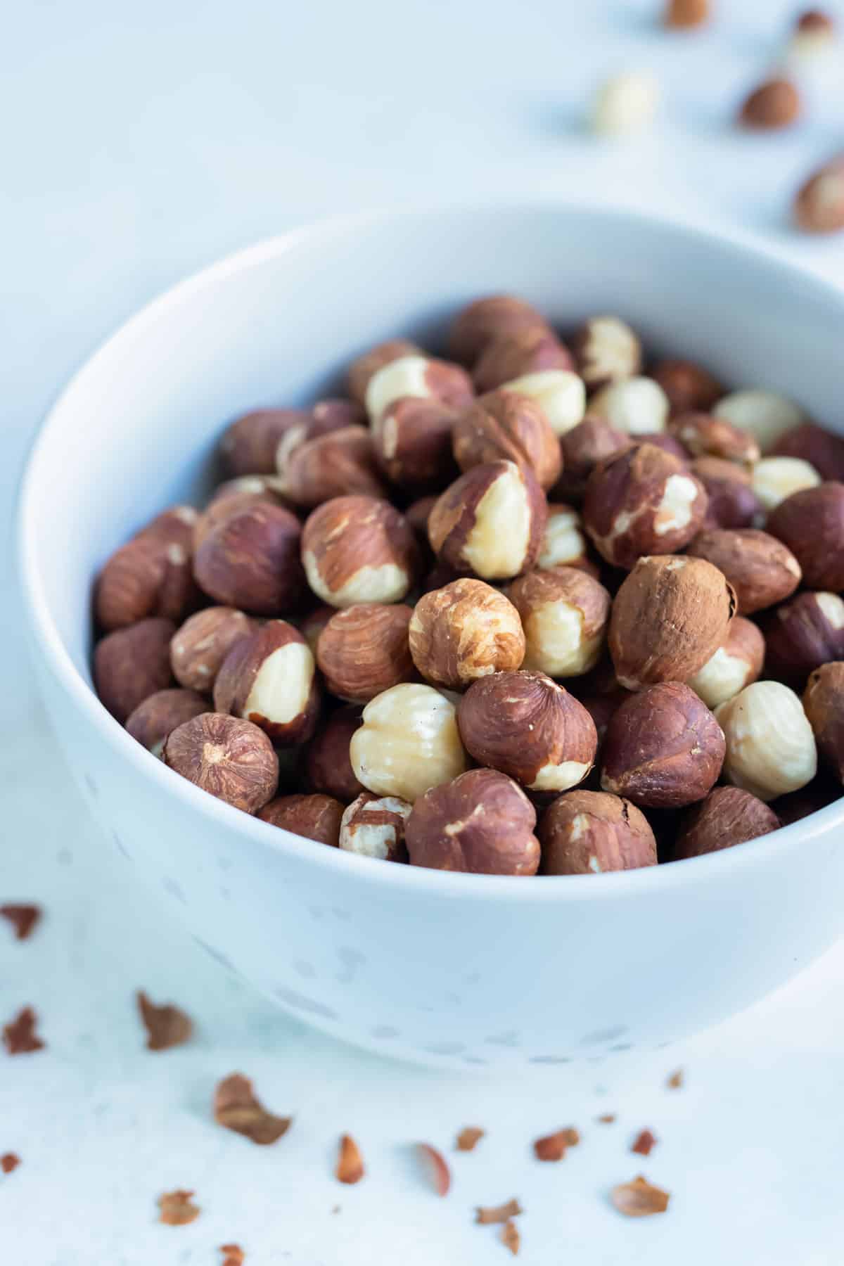 A bowl of toasted hazelnuts is set on the counter for snacking.