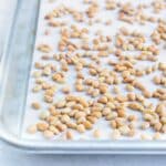 Parchment paper lines a baking sheet when roasting pine nuts with this quick and easy method.