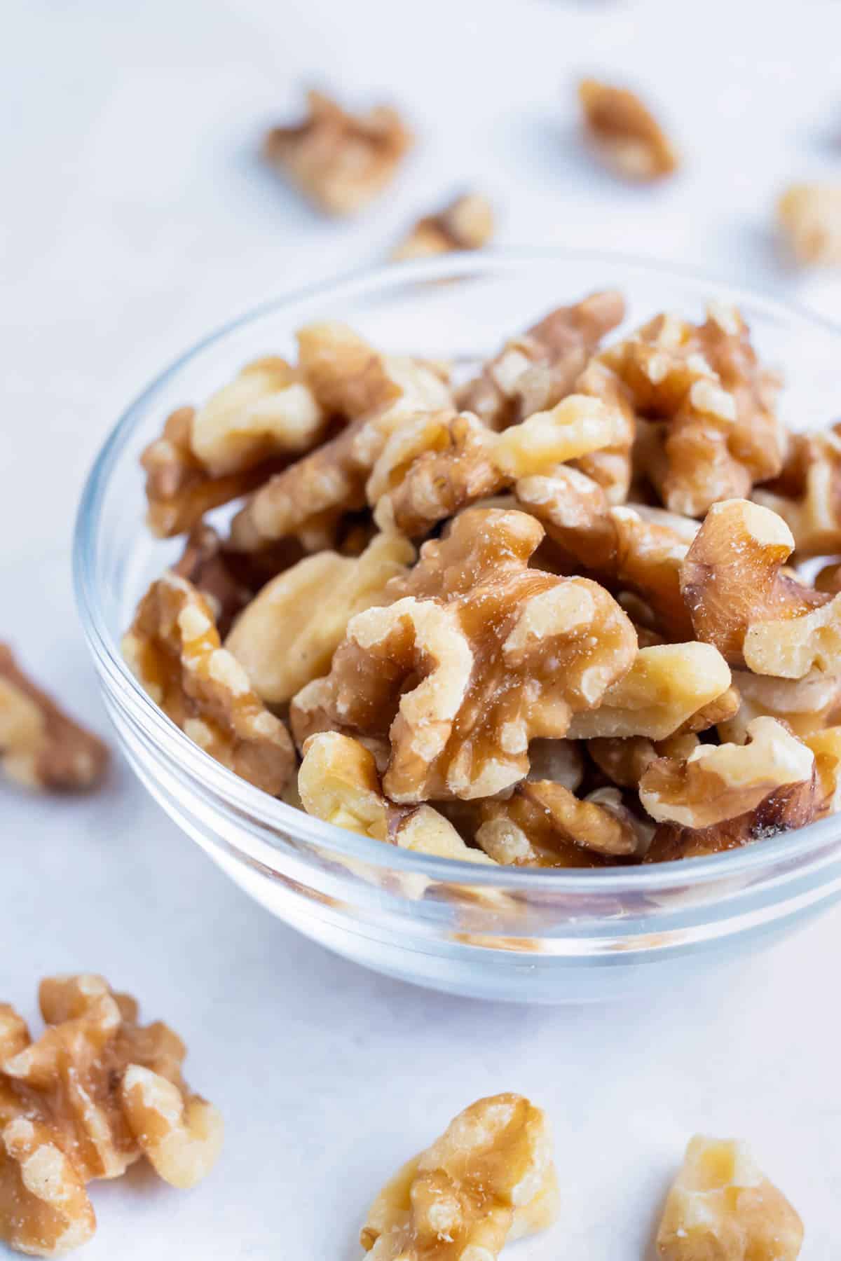 Toasted walnuts are placed in a bowl for a snack.