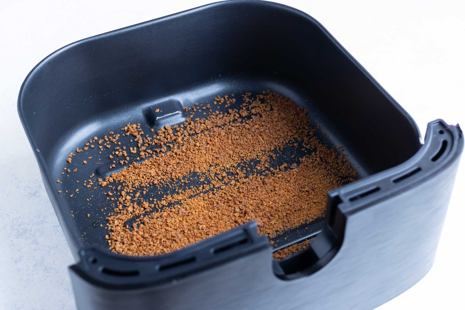 Leftover crumbs at the bottom of your air fryer basket.