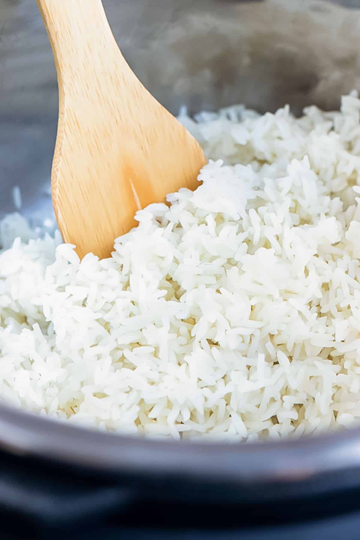 White rice in an Instant Pot with a wooden spoon.