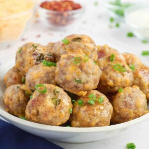 A plate full of sausage balls are ready to be served at a party.