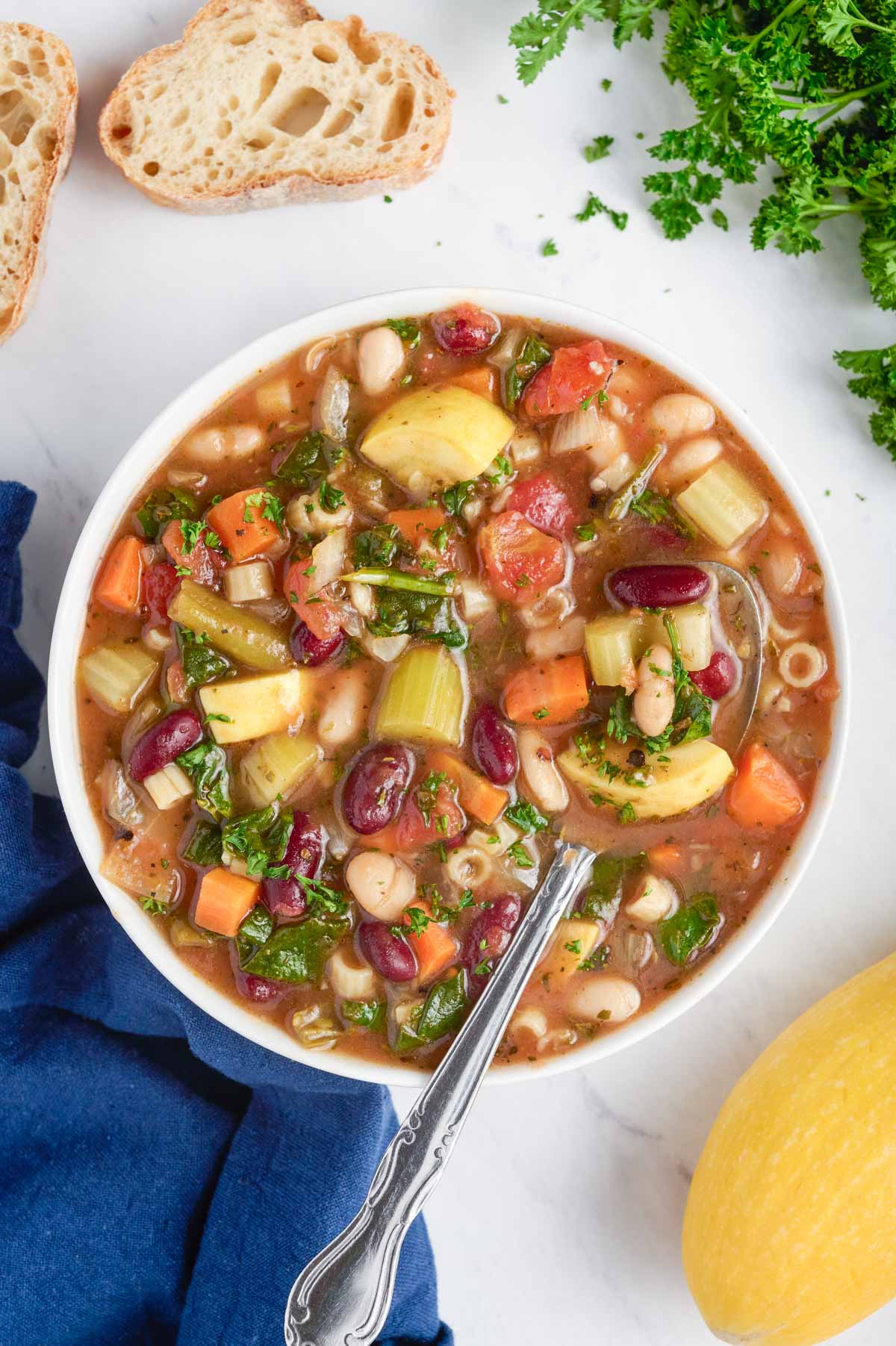 A big bowl full of healthy minestrone soup full of vegetables.