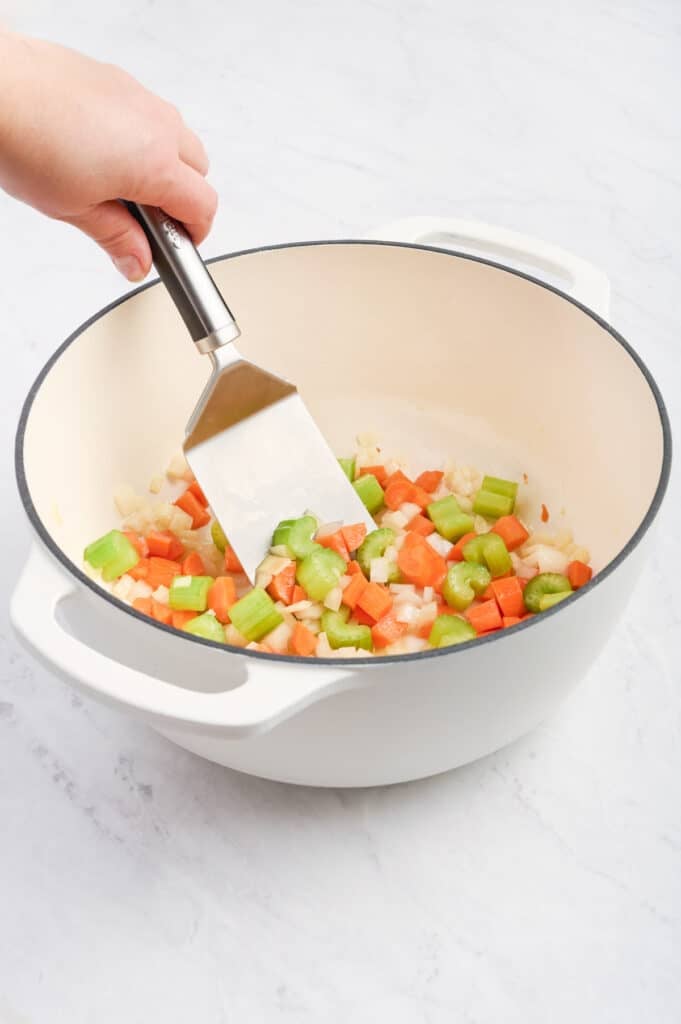 A spatula stirs the veggies.