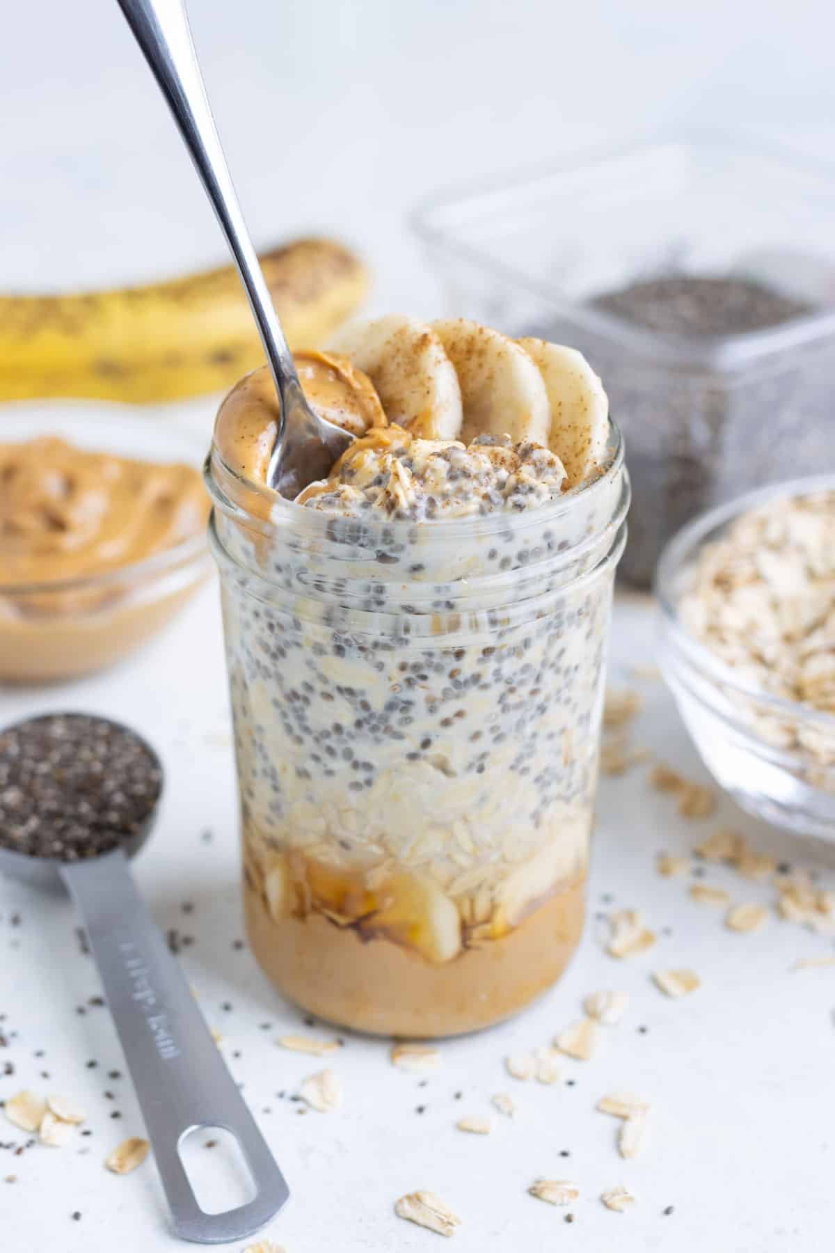 Mason jars are filled with healthy oatmeal ingredients for a quick breakfast.