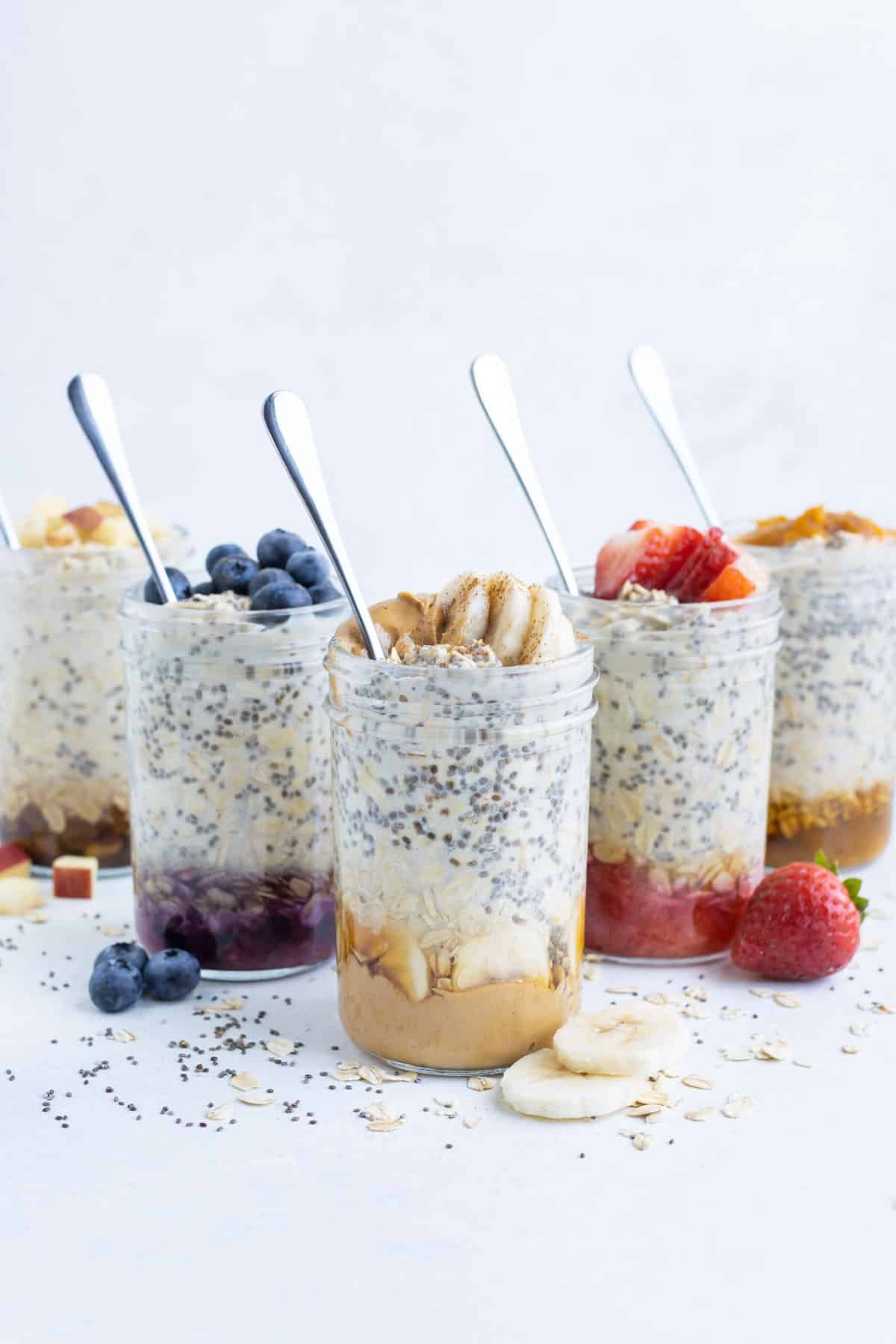 Five different varieties of overnight oats in jars.