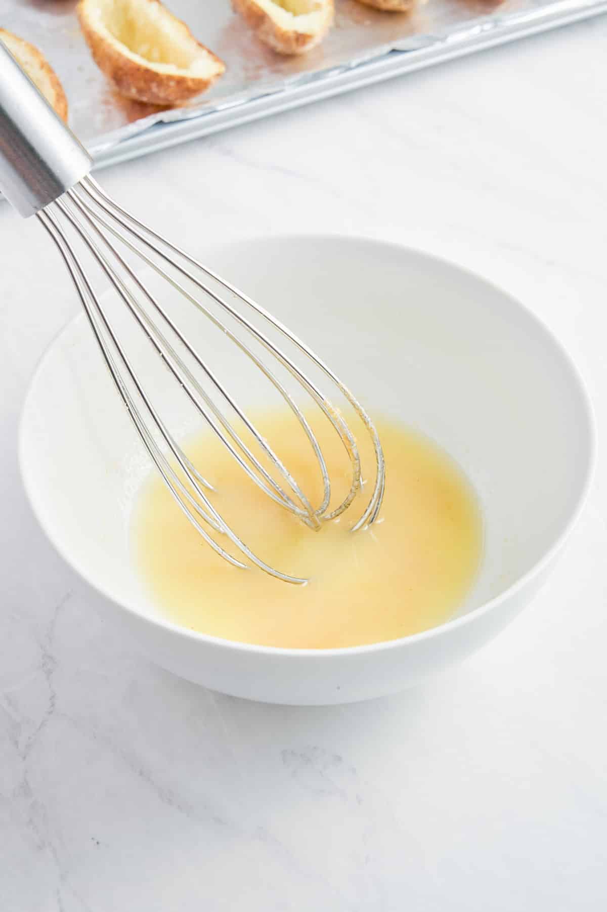 Melted butter and seasonings are mixed together.