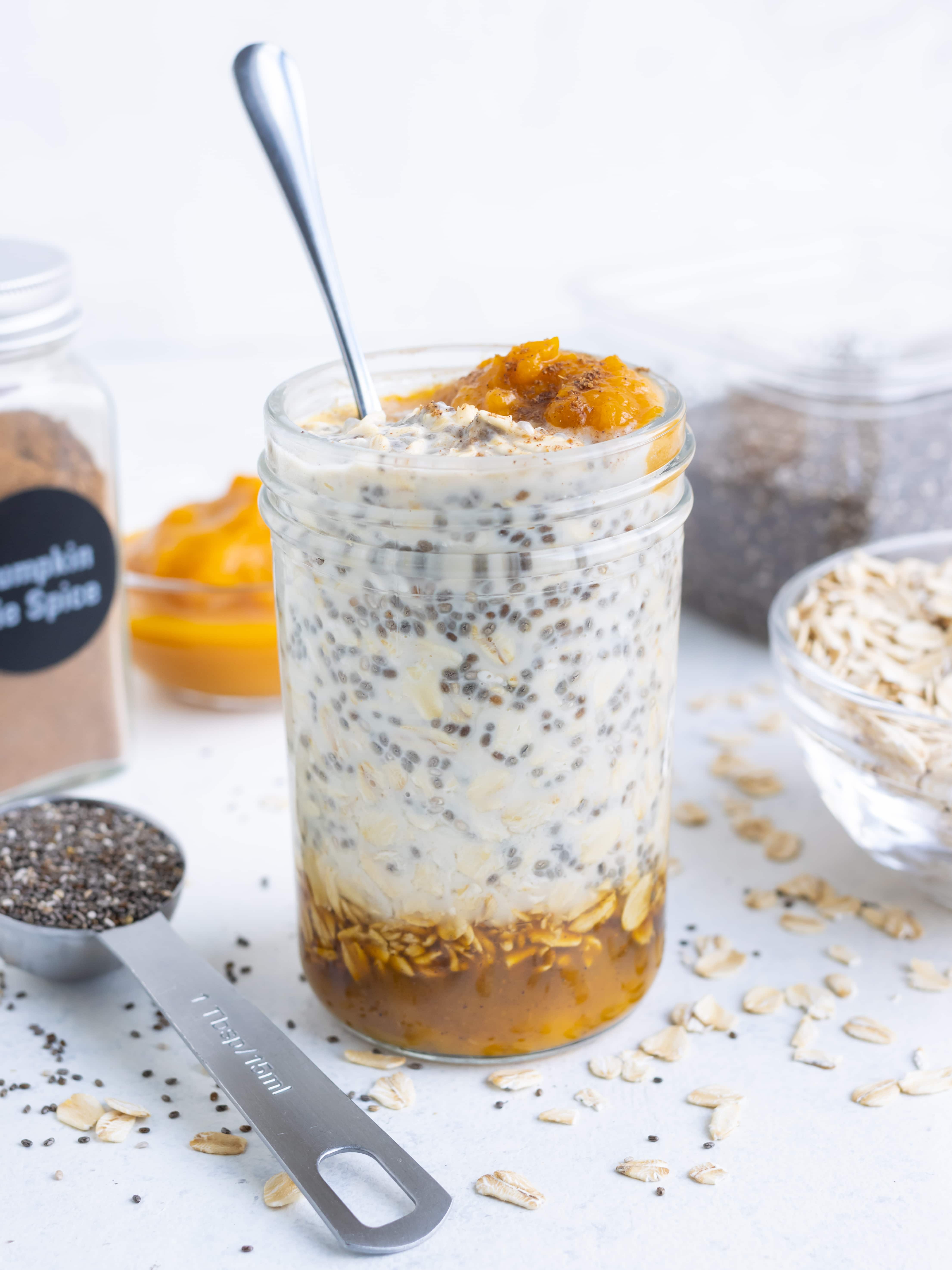 A spoon getting a bite of the best overnight oats from a glass mason jar.