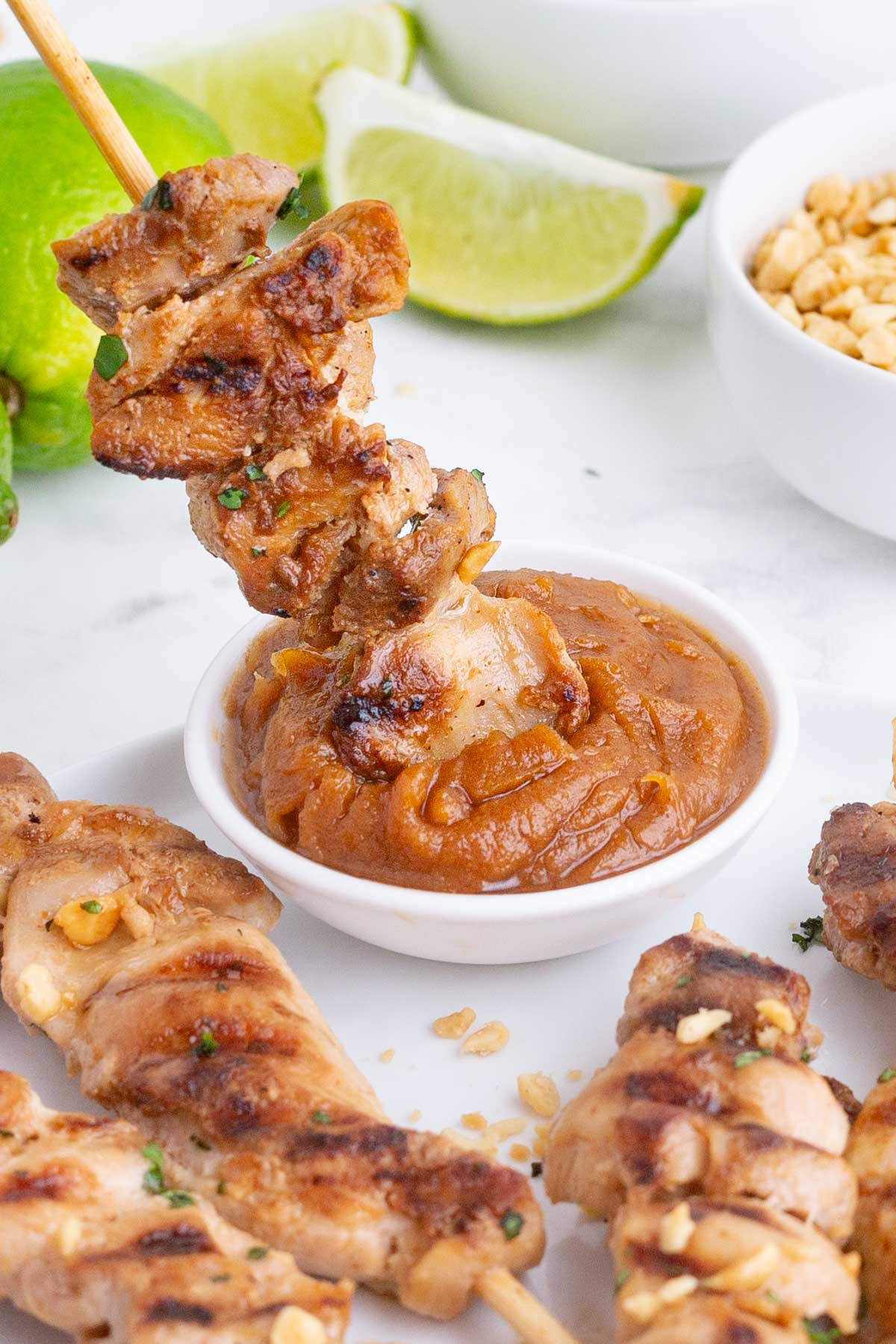 Serve chicken satay with peanut sauce and crushed peanuts.