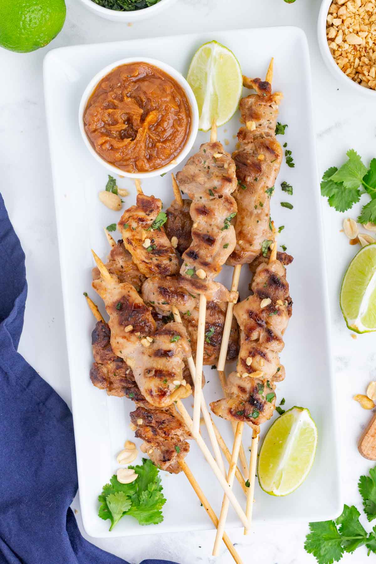 A rectangular plate with chicken stay skewers is served at a party.