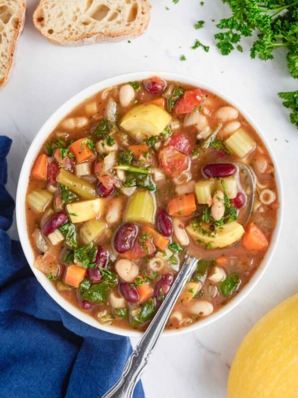 A big bowl full of healthy minestrone soup full of vegetables.