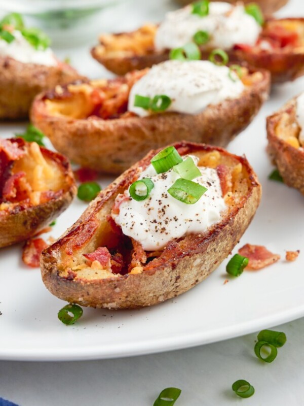 Potatoes are baked twice, topped with bacon and cheese, and served with sour cream and chives.