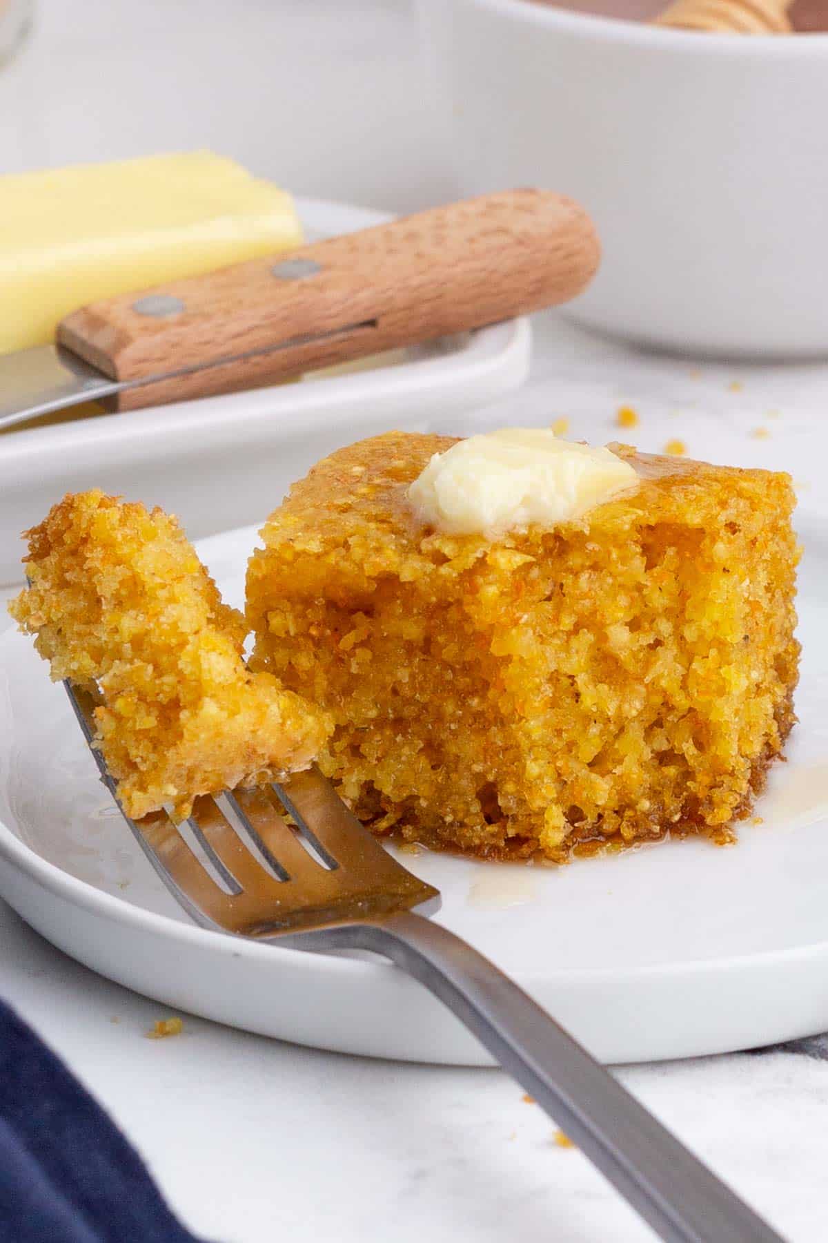 A bite of cornbread on a fork is ready to enjoy.